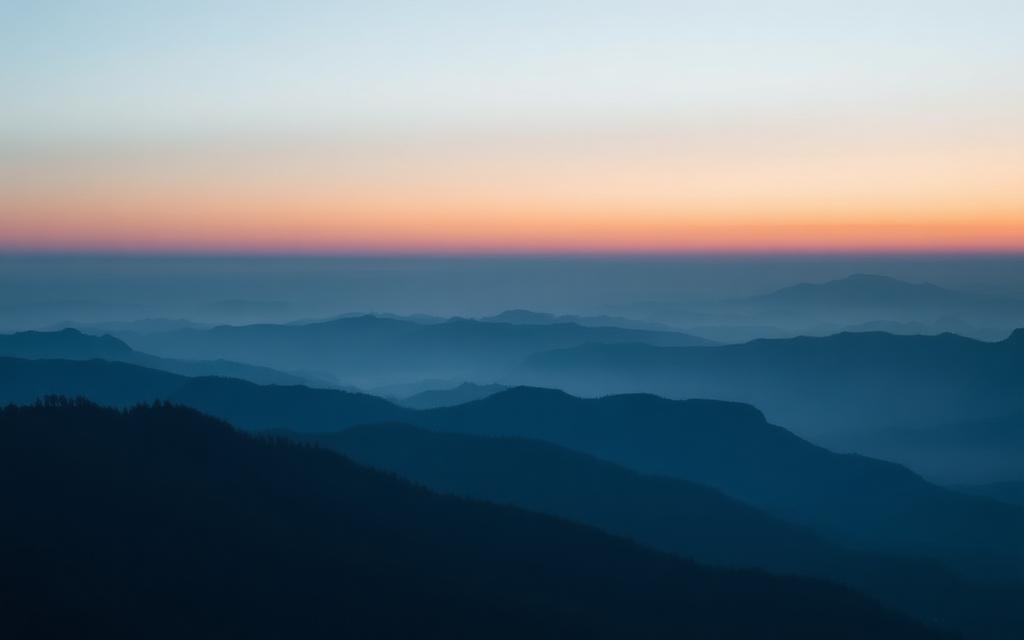 Sunrise over layered blue mountain ranges